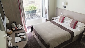 Une chambre d’hôtel avec un lit, une table de chevet, une lampe et une vue sur le balcon extérieur.