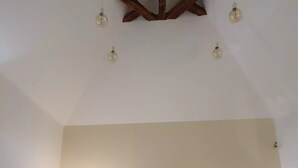 A bedroom with a bed, two bedside tables, and a ceiling light fixture. - The Dovecote (REILHAGUET)