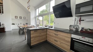 Una cucina moderna con una grande isola, un'area pranzo e un televisore montato a parete.
