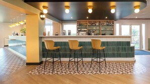 A bar area with a counter, three bar stools, and a tiled backsplash. - Sure Hotel by Best Western Caen Memorial (Caen)