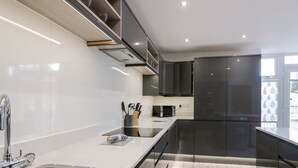 Eine moderne Küche mit Edelstahlgeräten, einer Spüle und Holzboden.