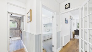 A hallway with a bed, a radiator, and a framed picture on the wall. - Glenvale - 2 Bedroom Apartment - Saundersfoot (Saundersfoot)
