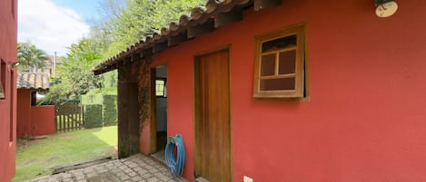 A red building with a tiled roof, a wooden door, and a small window.
