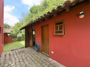 A red building with a tiled roof, a wooden door, and a small window.