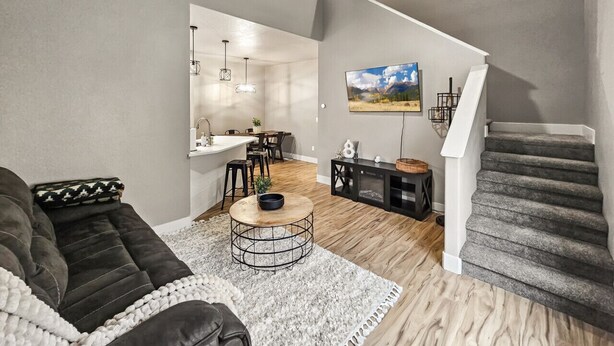 A modern living room with a sofa, coffee table, and staircase.