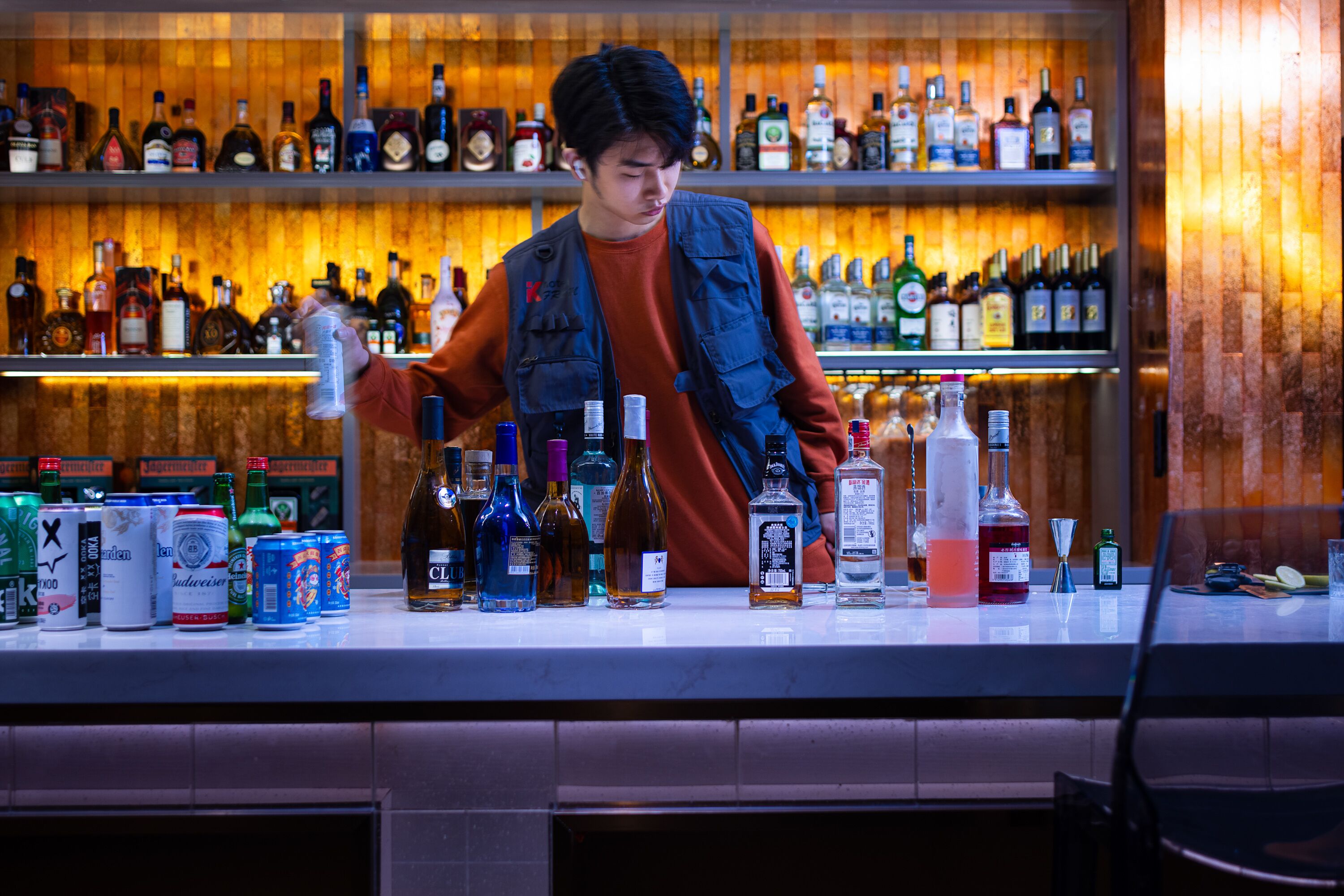 Eine Bar mit Regalen, gefüllt mit verschiedenen alkoholischen Getränken und Bierdosen.