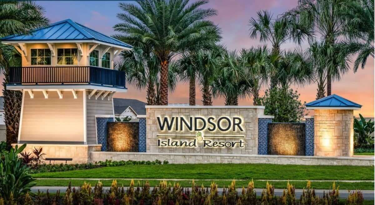 A resort sign with the name "Windsor Island Resort" and a building with a blue roof and balcony.