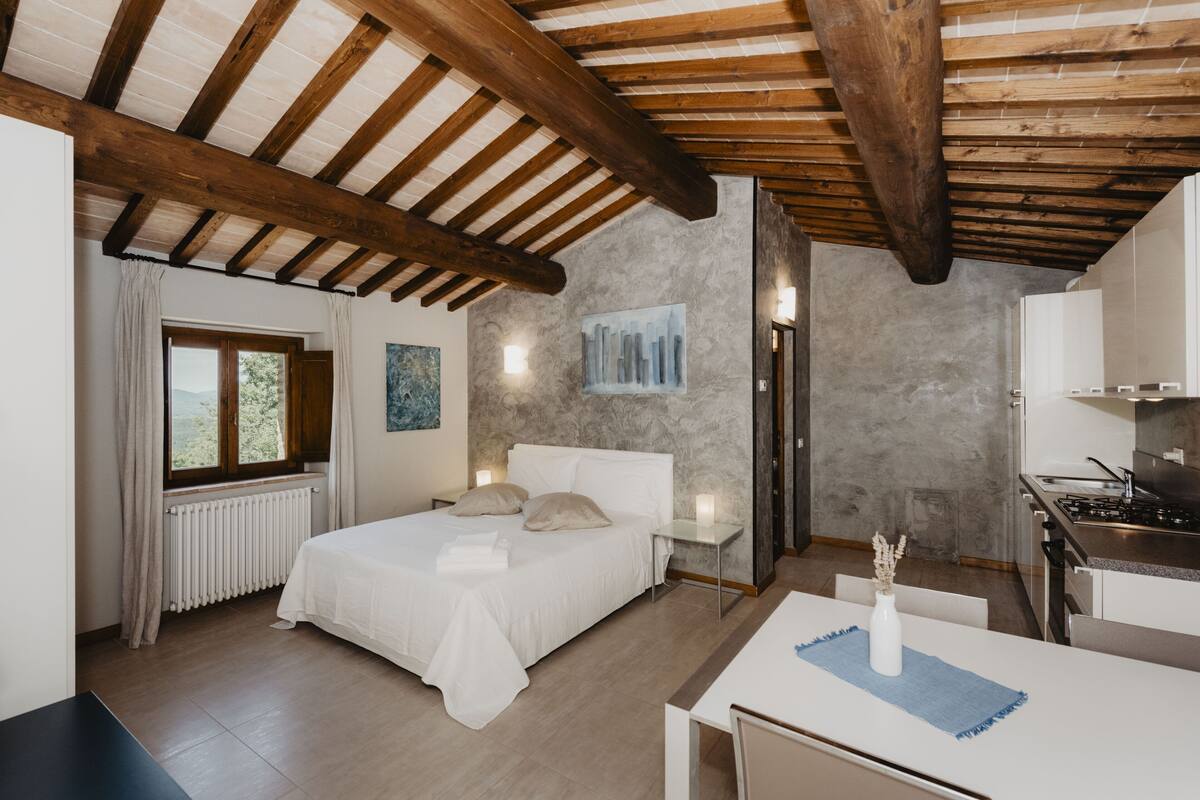A bedroom with a bed, bedside tables, and a window.