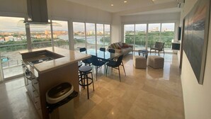 Una cocina moderna con una isla grande, comedor con sillas y un sofá.
