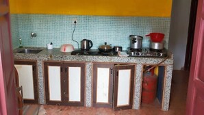 A compact kitchen with a tiled backsplash, a gas stove, and a sink.
