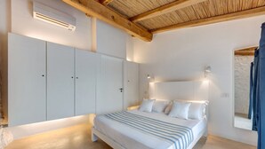 Un dormitorio con cama, armario blanco y techo con vigas de madera.