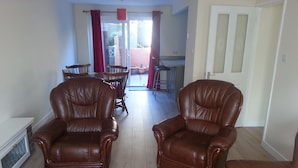 A living room with two brown leather armchairs, a red rug, and a view into a dining area with a table and chairs. - House - Sleeps 5 - Pets Ok - Parking - Garden (Bristol)