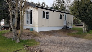A single-story mobile home with a front porch and a small attached garage.