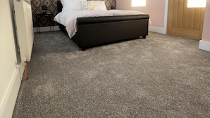 Un dormitorio con cama, escritorio, silla y radiador.