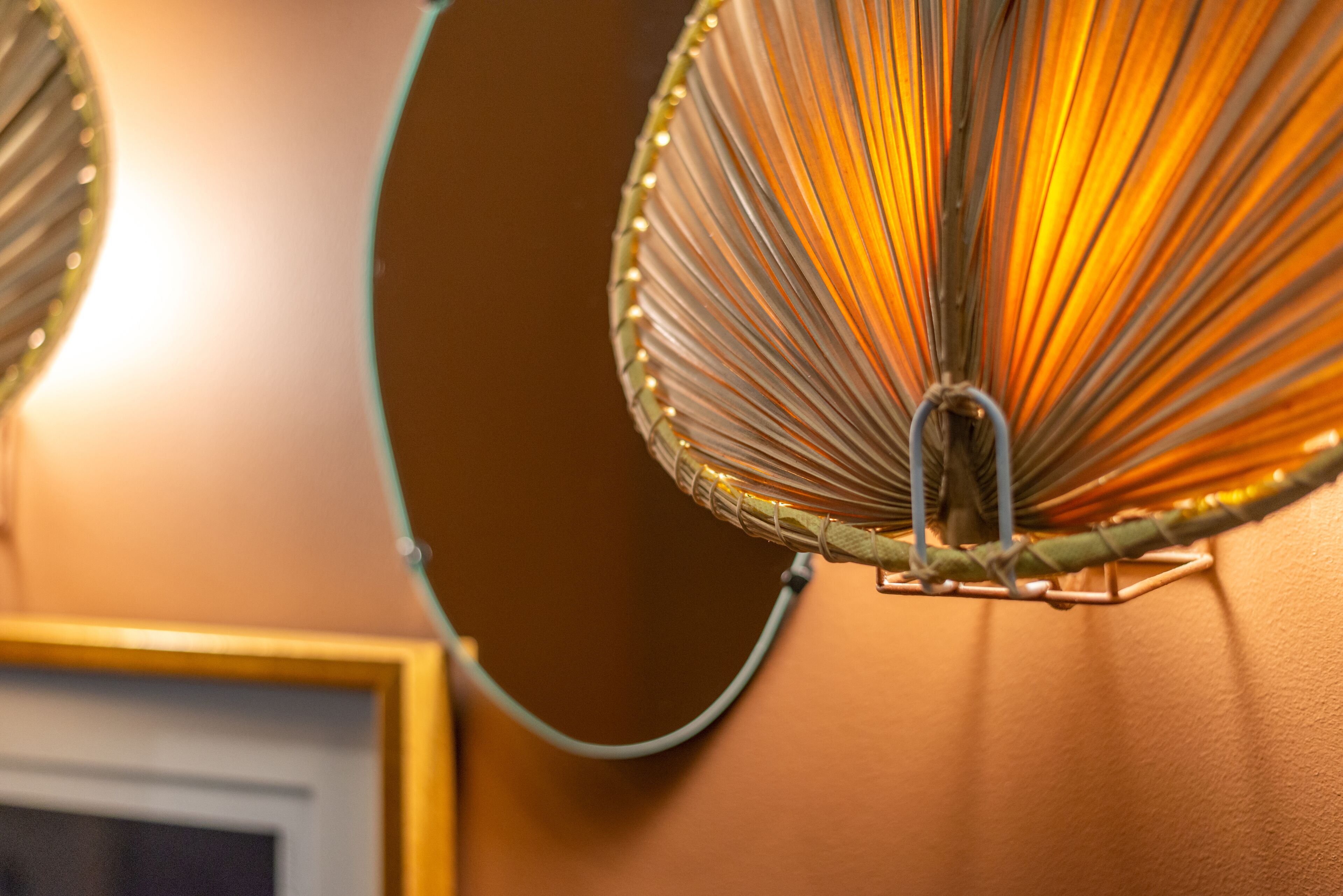 A close-up of a wall-mounted lamp with a circular shade and a visible cord.