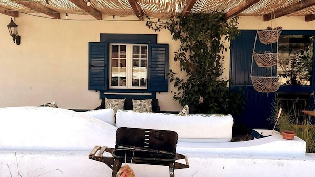A cozy outdoor seating area with a sofa and a grill. - Omontinho - 4-bed House With Pool in Melides (Grandola)