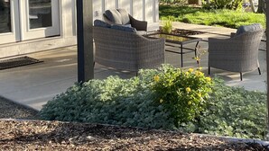 A covered outdoor seating area with wicker furniture and a garden in front. - Templeton Vineyard Farmhouse in the Heart of Wine Country  (Templeton)