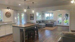 A spacious kitchen with a central island, a dining area with a sofa, and a large window offering a view of the outdoors. - Templeton Vineyard Farmhouse in the Heart of Wine Country  (Templeton)