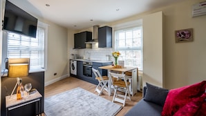 A modern kitchen with a dining area, a sofa, and a TV. - 44B Fishergate -  a couples retreat that sleeps 3 guests (York)