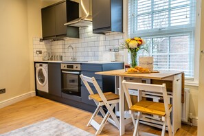 Enjoy meals in the kitchen with oven, compact washer and dryer, and a dining area with a table for two.