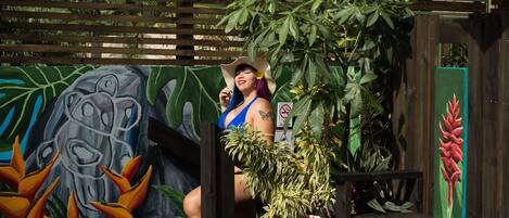 A pool area with a wooden fence, a mural, and a potted plant.