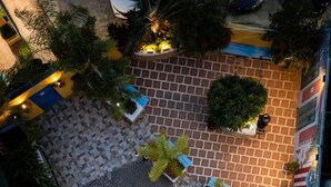 An aerial view of a courtyard with a central fountain, surrounded by potted plants and a tiled floor. - CALIZO VIP GUEST HOUSE  (Fajardo)