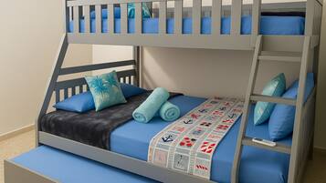 Una cama litera con dos niveles, ropa de cama azul y una manta estampada.