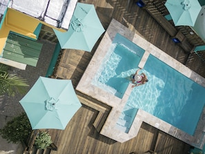 An aerial view of a swimming pool area with multiple umbrellas and lounge chairs. - CALIZO VIP GUEST HOUSE  (Fajardo)