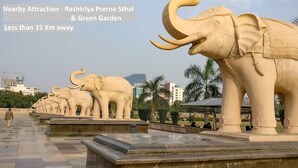 A row of elephant statues in a park setting. - OYO 13310 Noida Suites (Noida)