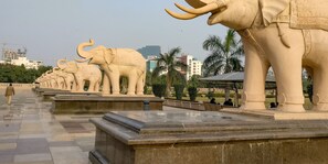 A row of elephant statues in a park setting. - OYO 13310 Noida Suites (Noida)