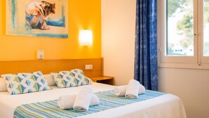 A hotel room with a bed, pillows, a painting, a nightstand, and a window with curtains. - Apartamentos Vista Playa I (Ciutadella de Menorca)