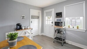 A compact kitchen with a coffee machine, microwave, and a small cart with kitchen tools. - Patty's Place - Private and Convenient Apartment near Downtown (Frederick)