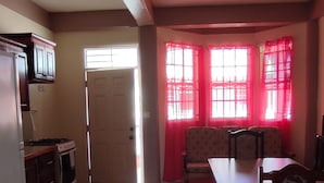 Une cuisine spacieuse avec un coin repas, comprenant une table et des chaises, un réfrigérateur et une cuisinière.