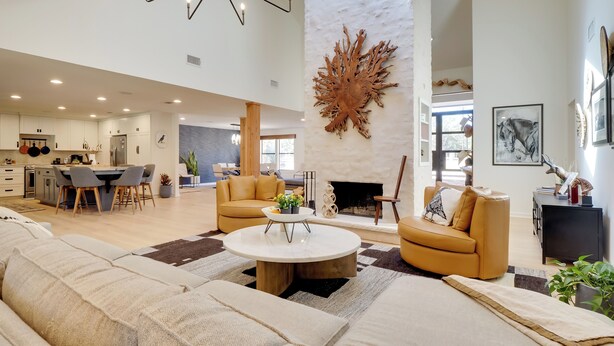 A spacious living room with a large sofa, a coffee table, and a fireplace.