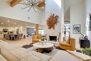 A spacious living room with a large sofa, a coffee table, and a fireplace. - Pool, Patio & Privacy! Home Near Georgetown Square (Georgetown)