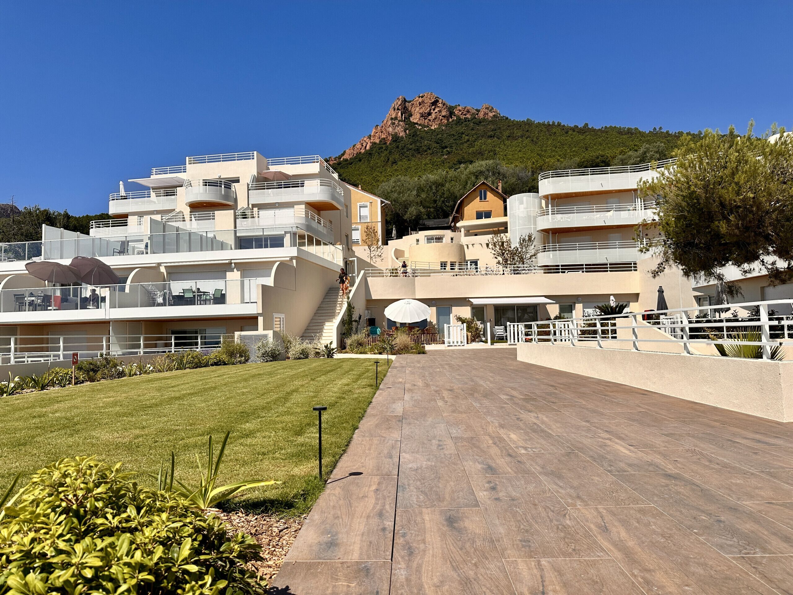 Un hôtel moderne doté de nombreux balcons, d’un escalier central et offrant une vue sur une montagne.