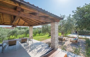 An outdoor patio with a pergola, stone pillars, and seating. - Villa Elise with Pool (Novigrad)