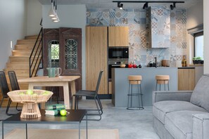 A modern kitchen with wooden cabinets, a built-in oven, and a patterned backsplash.