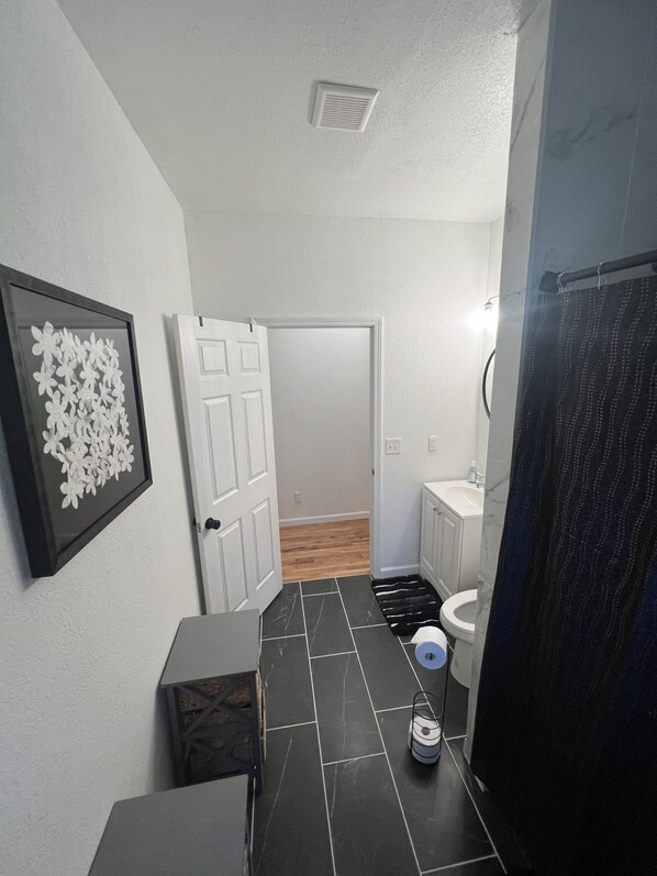 Een badkamer met toilet, wastafel en douche.