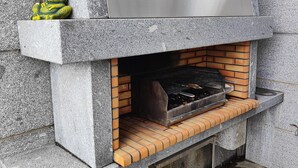 Una griglia esterna in pietra con coperchio metallico e base in mattoni.