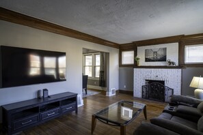 Relax in this stylish living room with a large flat-screen TV, comfortable sofa, and cozy fireplace.
