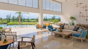 Amplio espacio interior con piscina, asientos exteriores y grandes ventanales con vistas a un paisaje pintoresco.