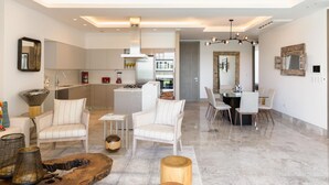 Una sala de estar moderna con comedor, cocina y un pasillo que lleva a un dormitorio.