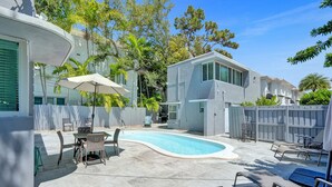 A backyard with a swimming pool, outdoor furniture, and a fenced area. - Retro Oasis by Las Olas (Fort Lauderdale)