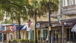 A row of Italian-themed storefronts with flags, including a wine bar and a cafe. - Retro Oasis by Las Olas (Fort Lauderdale)