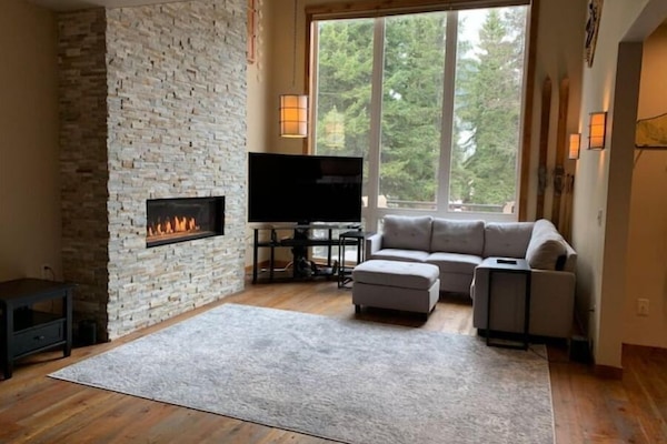This luxe living room boasts a cozy fireplace and picturesque views.