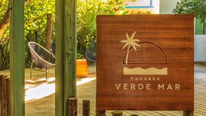 A wooden sign with a palm tree and waves, labeled "Pousada Verde Mar". - Pousada Verde Mar (Porto Seguro)