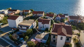 Vista aérea de una zona residencial costera con casas, una carretera y una masa de agua.