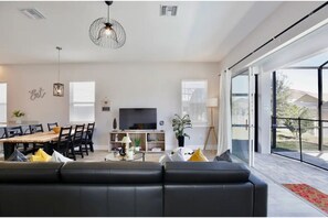 Relax in this stylish living space with a sofa, dining area, and flat-screen TV.