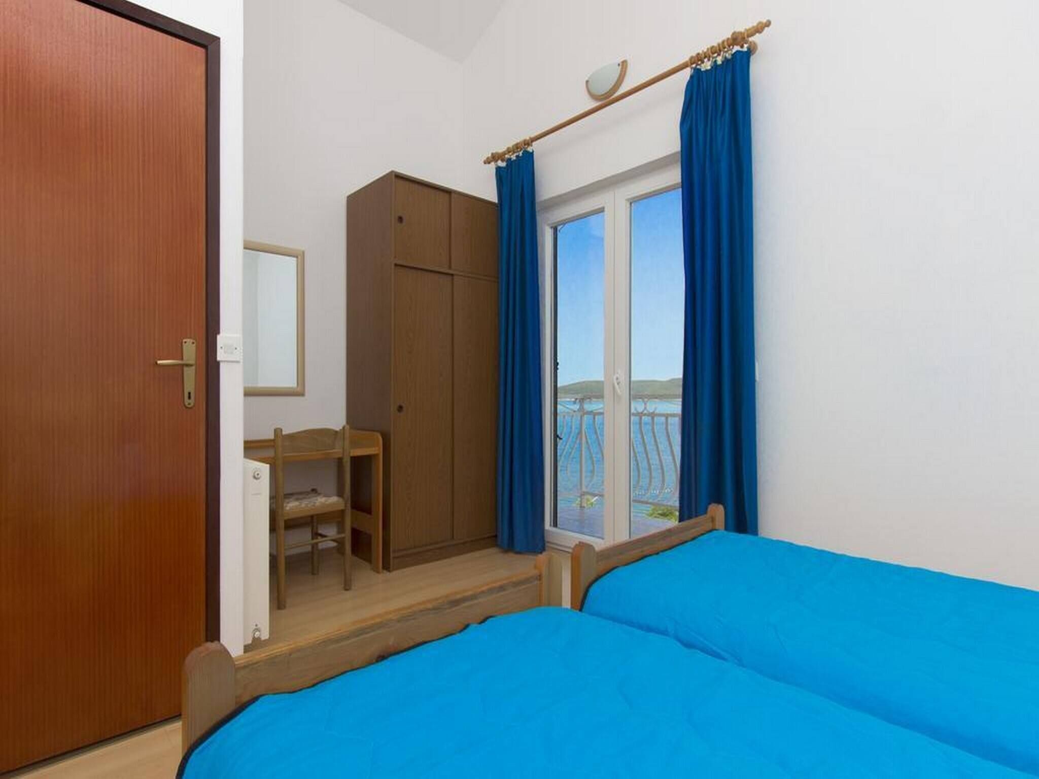 A bedroom with a bed, a desk, and a wardrobe.